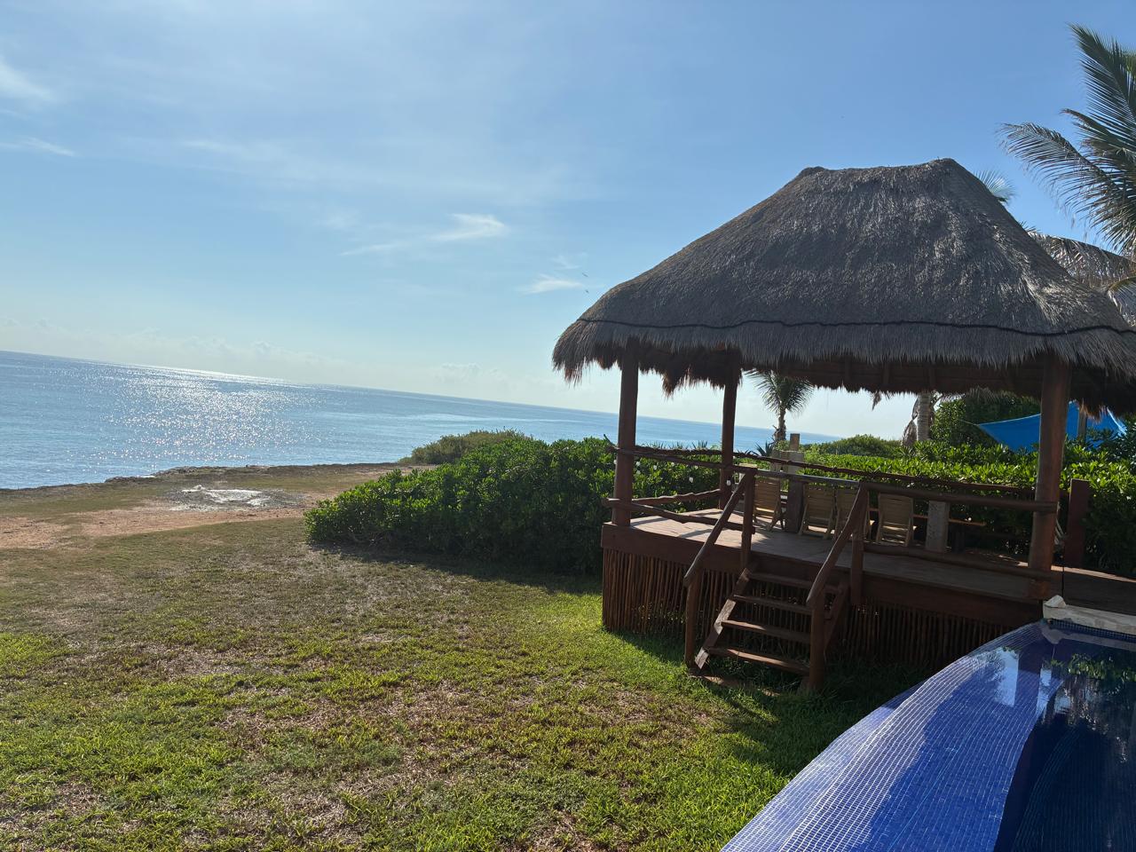 Palapa y alberca frente al mar