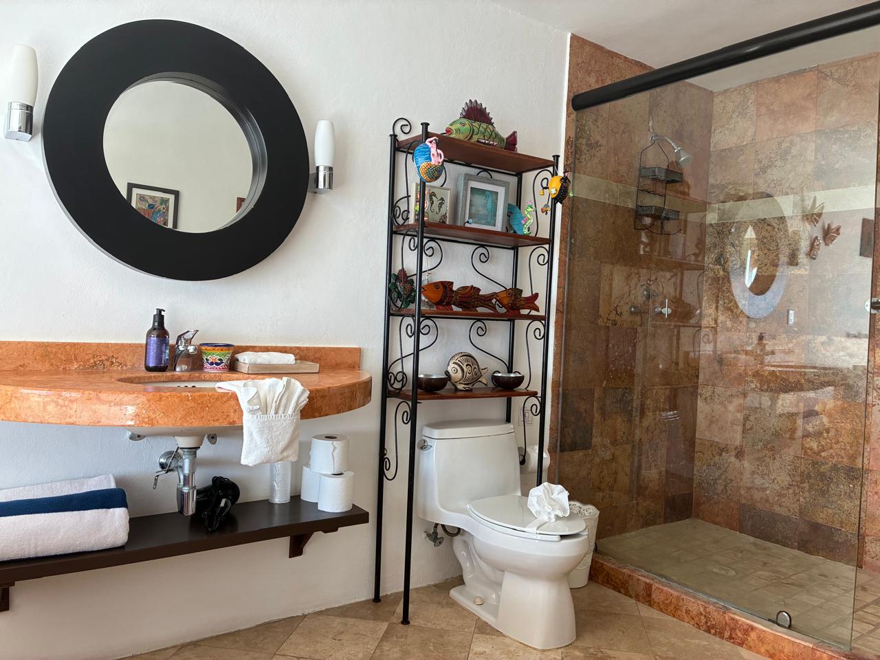 Espejo redondo, ducha y estante con peces