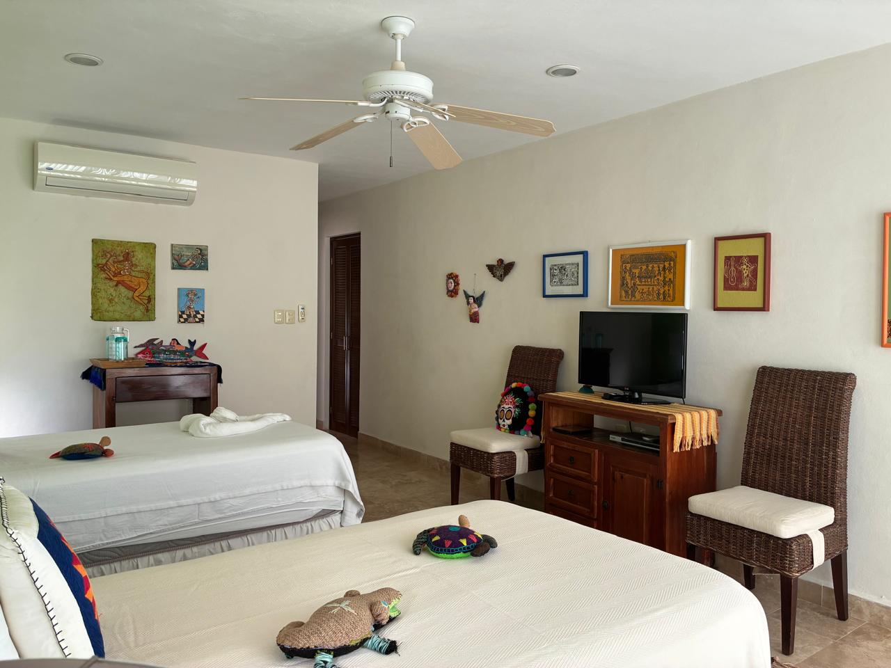 Habitación verde con dos camas y TV