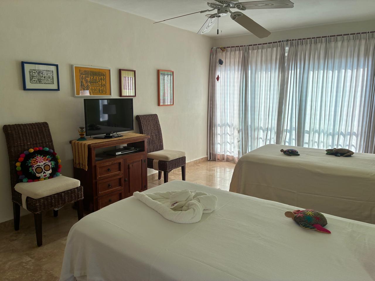 Habitación verde con TV y balcón